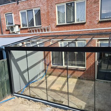 Veranda met glazen dak en voor een glasschuifwand